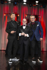 A picture of Kevin Hodes receiving an award with Zack Viscomi and Nick Nanton from Celebrity Branding Agency on either side of him.