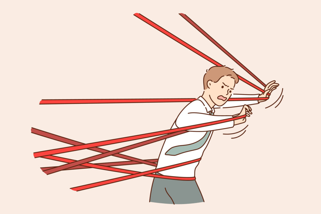 An illustration of a man struggling to get through tangled red tape.